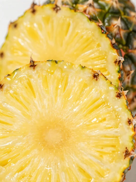 Fresh, sliced pineapple on a rustic wooden table
