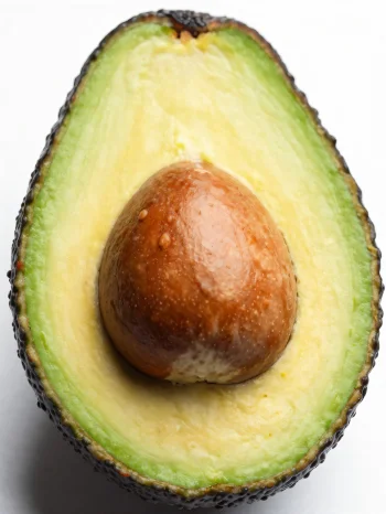 Cut fresh avocado with creamy green interior on a wooden surface