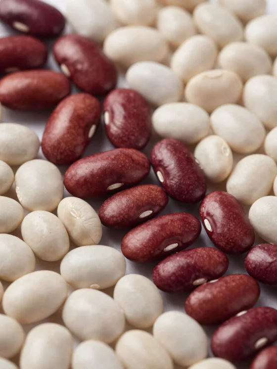 Different types of dry beans on a wooden table, in bowls and scattered