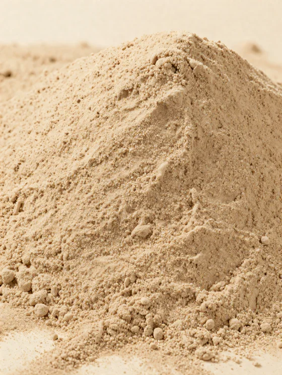 Light brown chestnut flour in a rustic bowl, scattered on a wooden surface