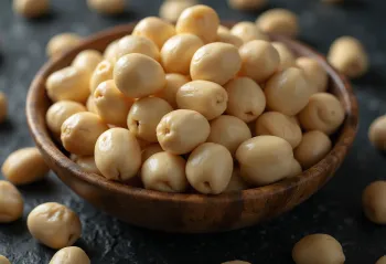 Shelled macadamia nuts in a natural pile, white background