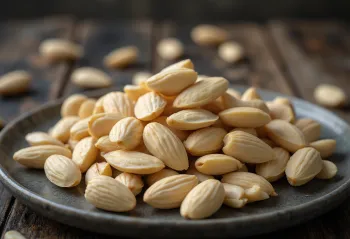 Blanched almond kernels in a natural pile on a white background