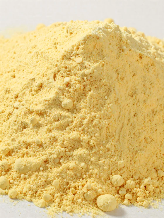Corn flour in a ceramic bowl, yellow, powdery flour on a wooden surface