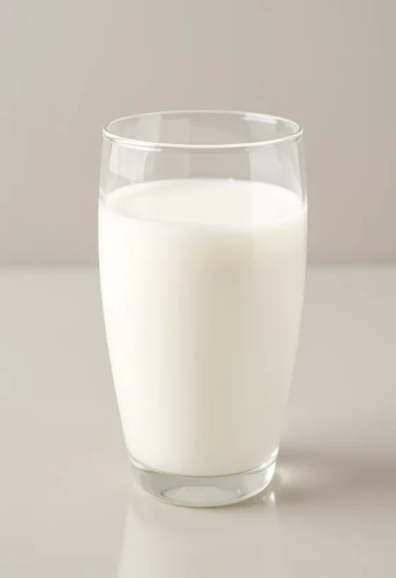 A glass and a bottle of fresh milk on a bright kitchen counter, without animal elements