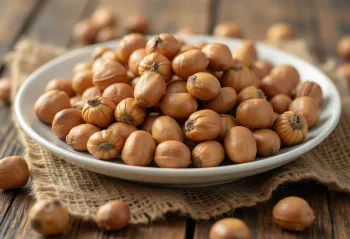 Shelled Turkish hazelnuts arranged in a pile on a white background, partially halved