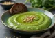 Broccoli leek cream soup served in a ceramic bowl, garnished with broccoli florets and leek rings