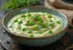 Creamy green pea sauce in a bowl garnished with fresh parsley.