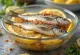 Pickled sardines in a glass jar with lemon and spices