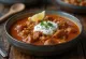 Creamy tripe soup garnished with paprika oil and lemon