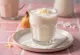 Coconut lassi in a glass with shredded coconut rim