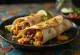 Pork burrito in tortilla with rice, beans, cheese