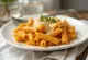 Creamy pumpkin baked pasta topped with melted vegan cheese.