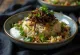 Mujaddara served with green lentils, crispy onions, and fresh cilantro