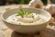 Creamy garlic rosemary sauce in a bowl, served with fresh rosemary and toasted bread.