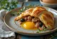 Salteña with hard-boiled egg, meaty filling, served with fresh cilantro
