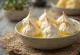 Floating Islands dessert in a glass bowl with vanilla custard