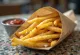 Golden brown french fries fried crisp and sprinkled with herbs.