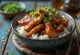 Glossy teriyaki chicken topped with sesame seeds and green onions